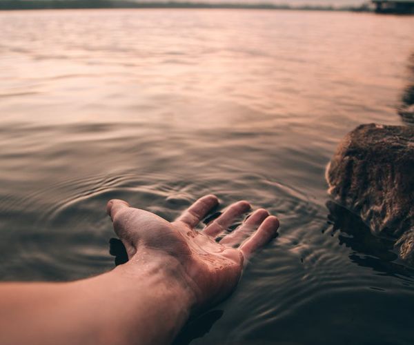 Person stretching outdoors during sunrise, feeling energized.